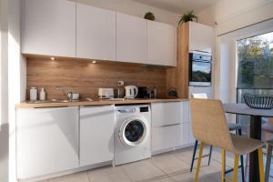a white kitchen with a washing machine and a table at Regard Marin - Appartement 4 pers in Le Palais