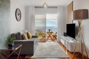 a living room with a couch and a television at Ti Clara View Apartment in Caniço