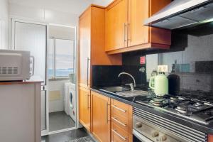 a kitchen with a stove and a sink and a microwave at Ti Clara View Apartment in Caniço