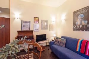 a living room with a blue couch and a tv at Case Sole e Luna in Genoa