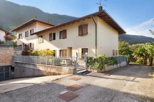 a white house with a fence and mountains in the background at Katzemburg 9999 in Arco