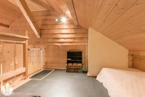 a bedroom with wooden walls and a bed in a room at Gîte Au Pré De La Basse in Orcier