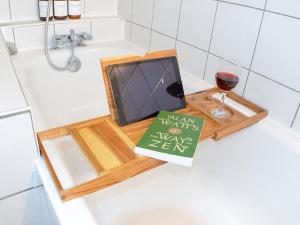 a book and a glass of wine in a bath tub at Le Nid, Duplex lumineux proche Colmar in Soultz-Haut-Rhin