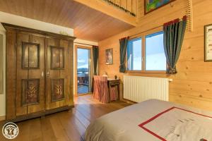 a bedroom with a bed and a large window at Gîte Au Pré De La Basse in Orcier