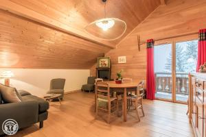 a living room with a wooden ceiling and a table at Gîte Au Pré De La Basse in Orcier