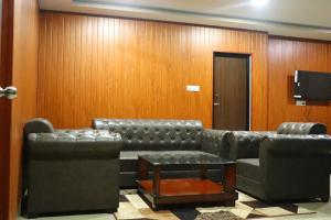 a waiting room with a couch and a television at Hotel Golden Mahseer in Tezu