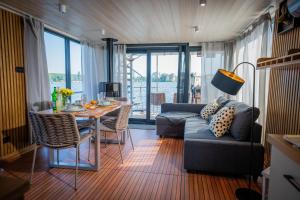 a living room with a couch and a table at Gemütliches Hausboot Aquila Woma in Fürstenberg