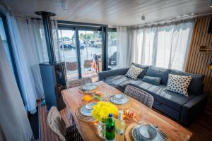 a living room with a table and a couch at Gemütliches Hausboot Aquila Woma in Fürstenberg +17 photos