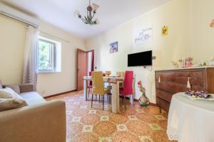 a living room with a table and a tv at Holiday Home Tommaso e Martina in Savoca