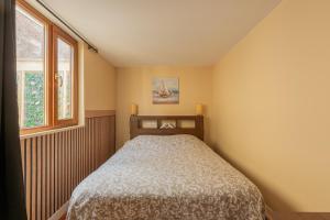 a small bedroom with a bed and two windows at Maison maxi 8 personnes, proche mer in Mers-les-Bains