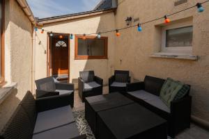 an outdoor patio with couches and chairs and lights at Maison maxi 8 personnes, proche mer in Mers-les-Bains