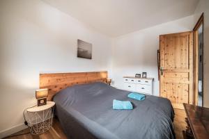 a bedroom with a large bed with a wooden headboard at Appart 6 pers – Accès direct Ski in Morillon