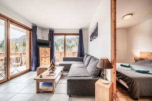 a living room with a couch and a bed at Appart 6 pers – Accès direct Ski in Morillon