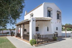 a white house with a fence in front of it at Cortijo Entrepinares in Conil de la Frontera