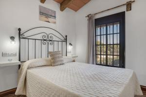 a bedroom with a large bed with a large window at Cortijo Entrepinares in Conil de la Frontera +78 photos