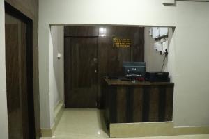 a room with a wooden door and a room with a counter at Hotel Golden Mahseer in Tezu