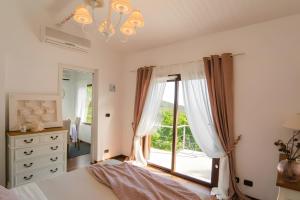 a bedroom with a bed and a large window at Villetta Antonia in Marina di Andora
