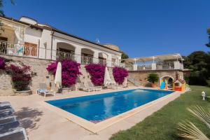 a villa with a swimming pool in front of a building at Villetta Antonia in Marina di Andora