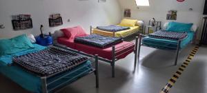 a room with four beds and chairs in it at Guidon Fourchette et table d'hôtes in Saint-Bonnet-de-Salers