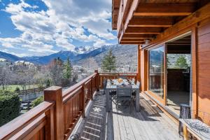 a wooden deck with a table on it at Chambre D'hôte au Chalet Datcha in Briançon