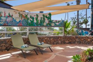 two chairs in front of a wall with a mural at Villa Dafmir in Tías