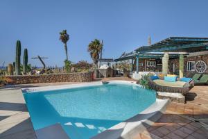 a swimming pool in a patio with a table and chairs at Villa Dafmir in Tías