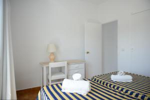 two beds in a room with a desk and a chair at Apartamento Ciel Azul in Santa Eularia des Riu +5 photos