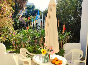 a table with a white umbrella and a vase of flowers at Apartamento Ciel Azul in Santa Eularia des Riu
