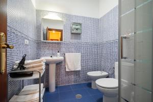 a blue tiled bathroom with a toilet and a sink at Apartamentos Les Cuartes in Cangas de Onís +35 photos