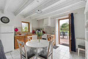 a kitchen with a table and chairs in a kitchen at Gite Hirondelle in Lanvallay