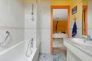 a bathroom with a tub and a sink at Gite Hirondelle in Lanvallay +13 photos
