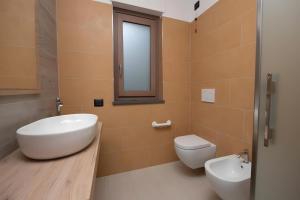 a bathroom with a sink and a toilet and a window at Appartamenti Suly 5 - Cir 0086 in Saint Vincent