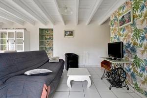 a living room with a couch and a desk with a computer at Gite Hirondelle in Lanvallay