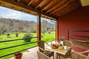 a patio with a table and chairs and a large window at Apartamentos Les Cuartes in Cangas de Onís