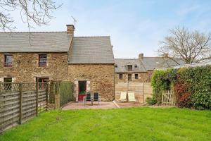 an old stone house with a fence and a yard at Gite Hirondelle in Lanvallay
