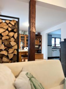 a living room with a couch and a pile of logs at Ferienwohnung Immergrün in Stetten am Kalten Markt