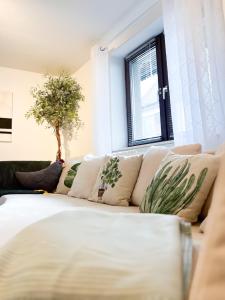 a living room with a white couch with pillows at Ferienwohnung Immergrün in Stetten am Kalten Markt