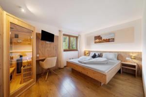 a bedroom with a bed and a desk with a computer at Waldheim in Verano