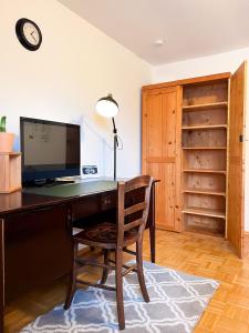 a desk with a computer and a chair in a room at Ferienwohnung Immergrün in Stetten am Kalten Markt