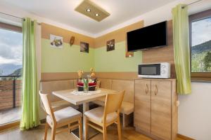 a small dining room with a table and a tv at Waldheim in Verano
