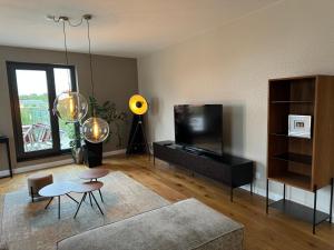 a living room with a couch and a television at 180qm Penthouse mit Sonnenterrasse in Rostock +36 photos
