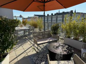 a patio with tables and chairs and an umbrella at 180qm Penthouse mit Sonnenterrasse in Rostock
