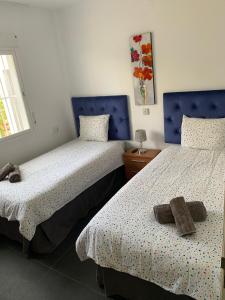 a bedroom with two beds with towels on them at Beach Bungalow in Torrox