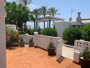 a patio with potted plants and a white fence at Beach Bungalow in Torrox