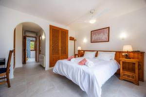 a bedroom with a large white bed and a desk at Villa Carla in Port de Soller +25 photos