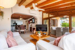 a living room with white furniture and a flat screen tv at Villa Carla in Port de Soller