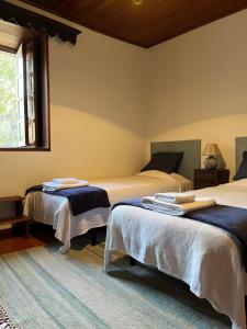a bedroom with two beds and a window at Casa Da Azenha in Baião