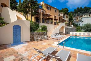a villa with a swimming pool and chairs at Villa Carla in Port de Soller