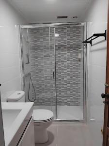 a white bathroom with a shower and a toilet at Casa Da Azenha in Baião