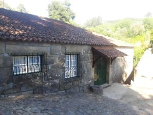 a stone building with a door and a window at Casa Da Azenha in Baião